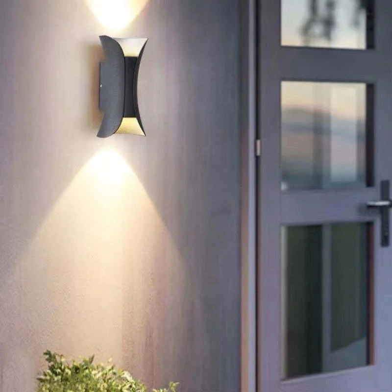 Modern outdoor LED wall light with curved design directing light up and down